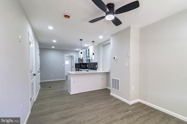 kitchen with ceiling fan, white cabinets, visible vents, wood finished floors, and baseboards