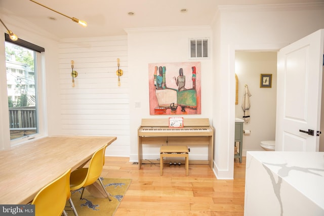 home office featuring crown molding, wood walls, and hardwood / wood-style floors