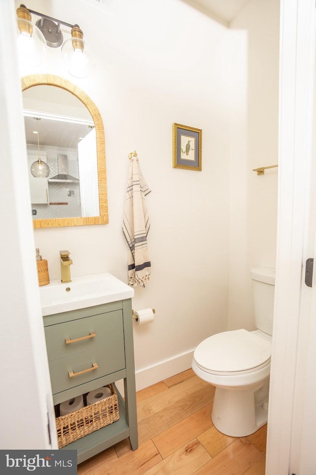 bathroom with vanity, hardwood / wood-style flooring, and toilet