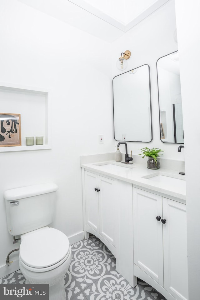 bathroom with toilet, tile patterned flooring, and vanity