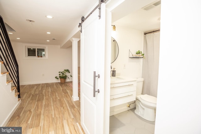 bathroom with hardwood / wood-style floors, vanity, and toilet