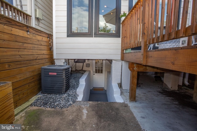 details featuring cooling unit, wooden walls, and concrete floors