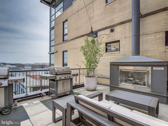 view of patio with an outdoor fireplace and area for grilling