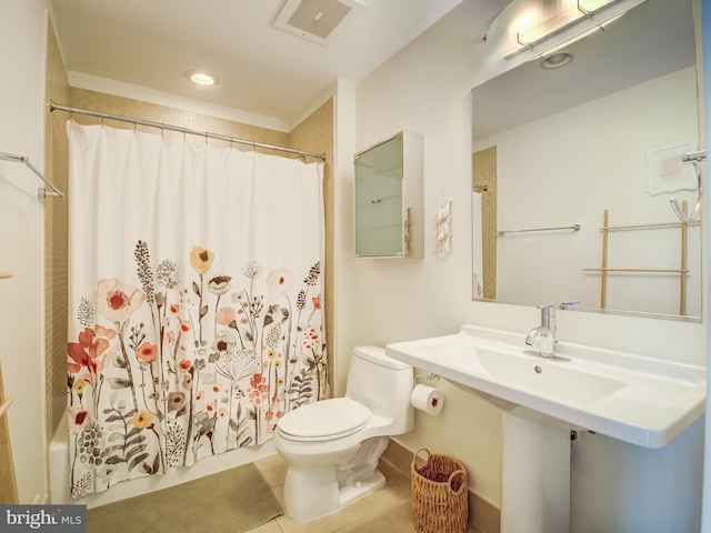 bathroom with tile patterned flooring, shower / bath combo with shower curtain, and toilet