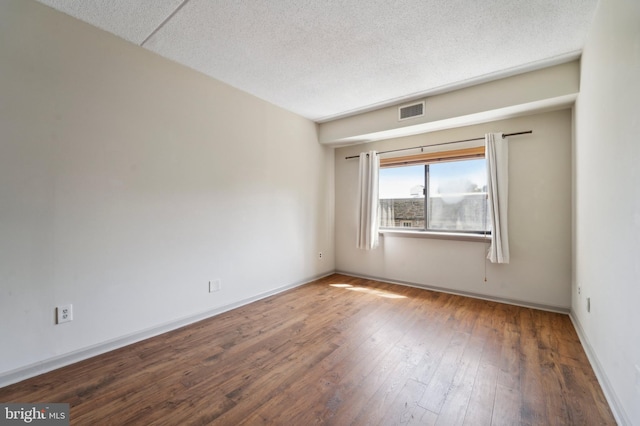 unfurnished room featuring hardwood / wood-style floors and a textured ceiling