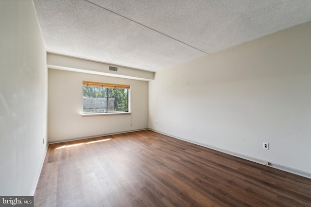 spare room featuring a textured ceiling and hardwood / wood-style floors