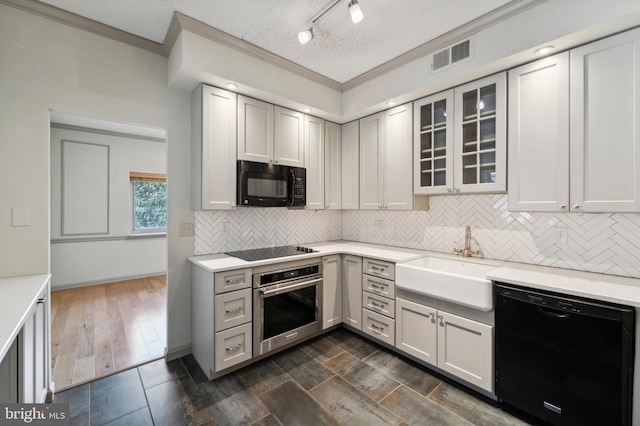 kitchen featuring sink, a textured ceiling, black appliances, dark hardwood / wood-style floors, and crown molding