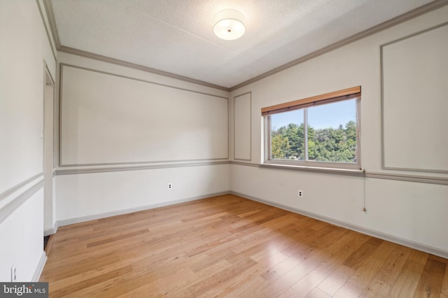 unfurnished room featuring crown molding, light wood-type flooring, and a textured ceiling