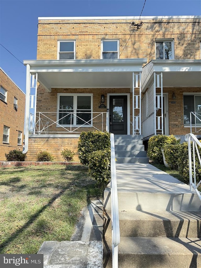 view of front of house with a front yard and a porch