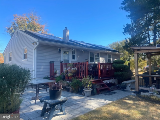 rear view of property with a deck and a patio area