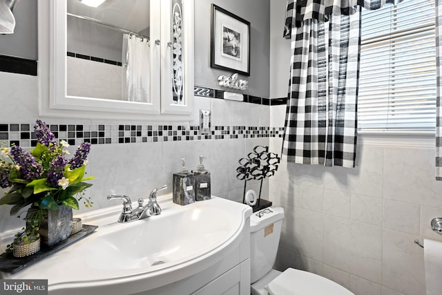 bathroom featuring toilet and tile walls