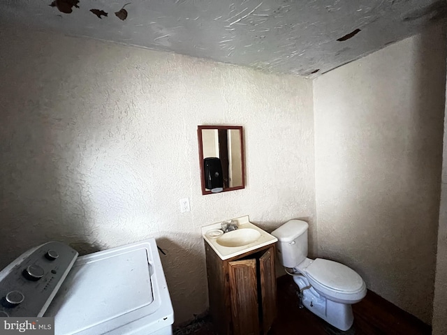 bathroom with washer / clothes dryer, vanity, and toilet