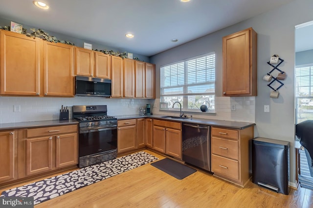 kitchen with sink, stainless steel appliances, light wood-type flooring, and tasteful backsplash