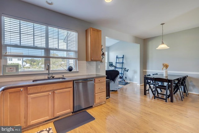 kitchen with decorative backsplash, dishwasher, light hardwood / wood-style flooring, sink, and pendant lighting