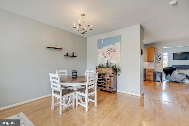 dining room with light hardwood / wood-style flooring and an inviting chandelier