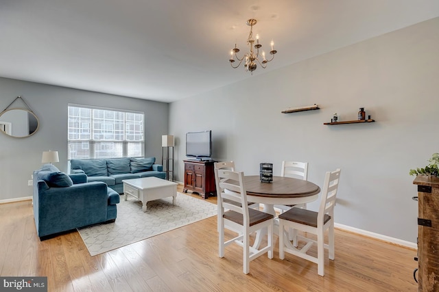 dining area featuring a notable chandelier and light wood-type flooring