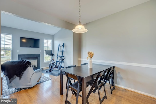 dining room with lofted ceiling, light wood-type flooring, and plenty of natural light