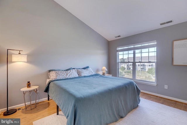 bedroom featuring light hardwood / wood-style floors and vaulted ceiling