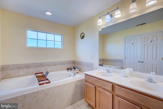 bathroom featuring vanity, a relaxing tiled tub, and tile patterned floors