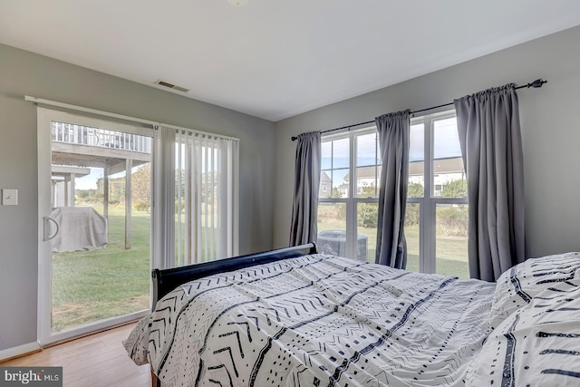 bedroom featuring access to outside and hardwood / wood-style floors