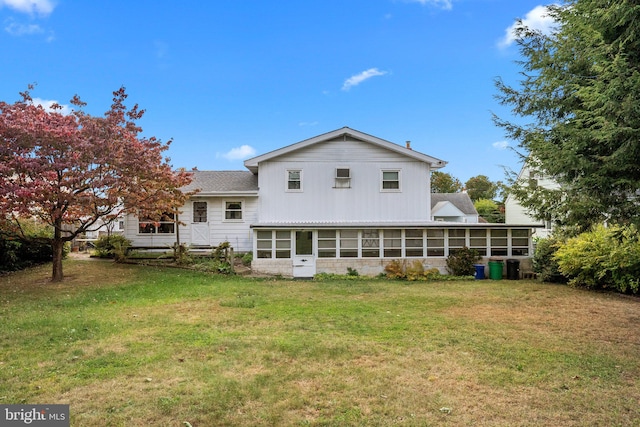 back of house featuring a yard and a sunroom