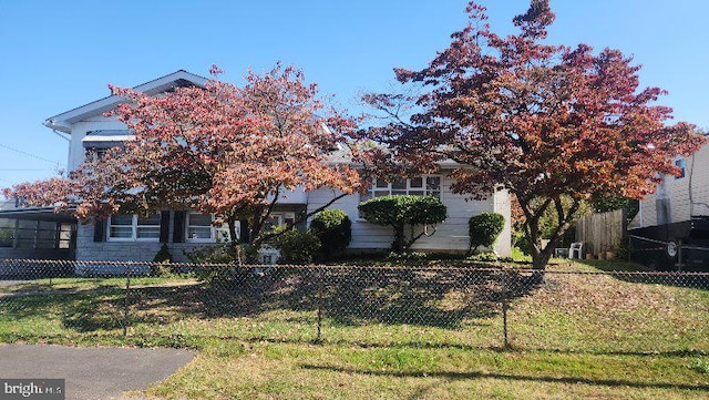 obstructed view of property featuring a front lawn