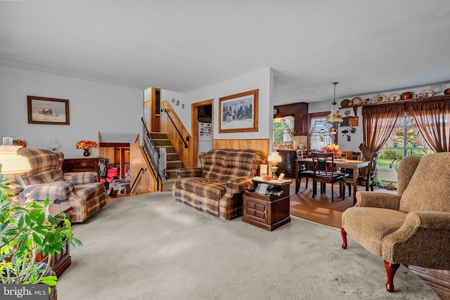 carpeted living room featuring wooden walls