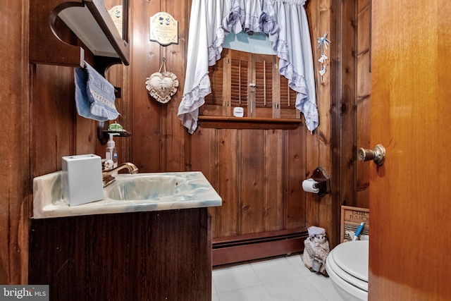 bathroom with vanity, wood walls, tile patterned floors, a baseboard radiator, and toilet