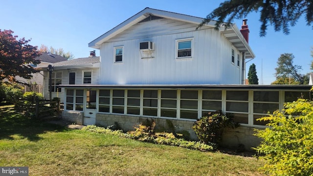 back of property featuring a yard and a sunroom