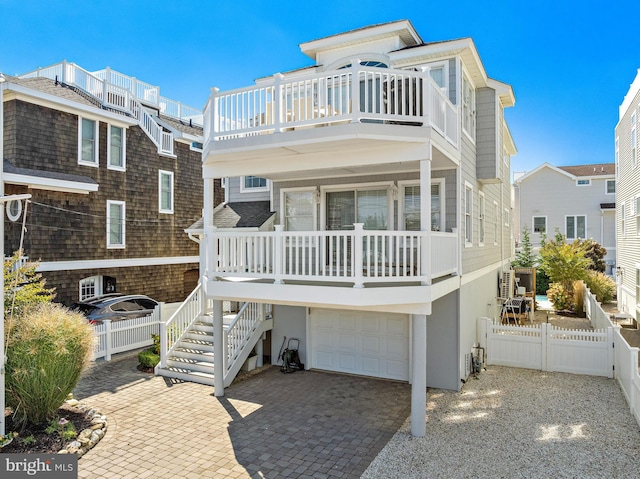 raised beach house featuring a balcony and a garage