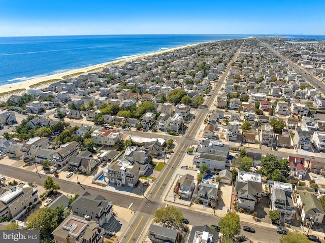 drone / aerial view featuring a water view and a view of the beach