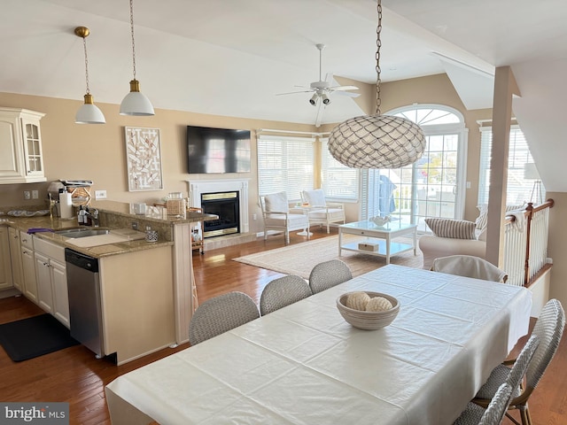 dining space with sink, ceiling fan, dark wood-type flooring, and vaulted ceiling