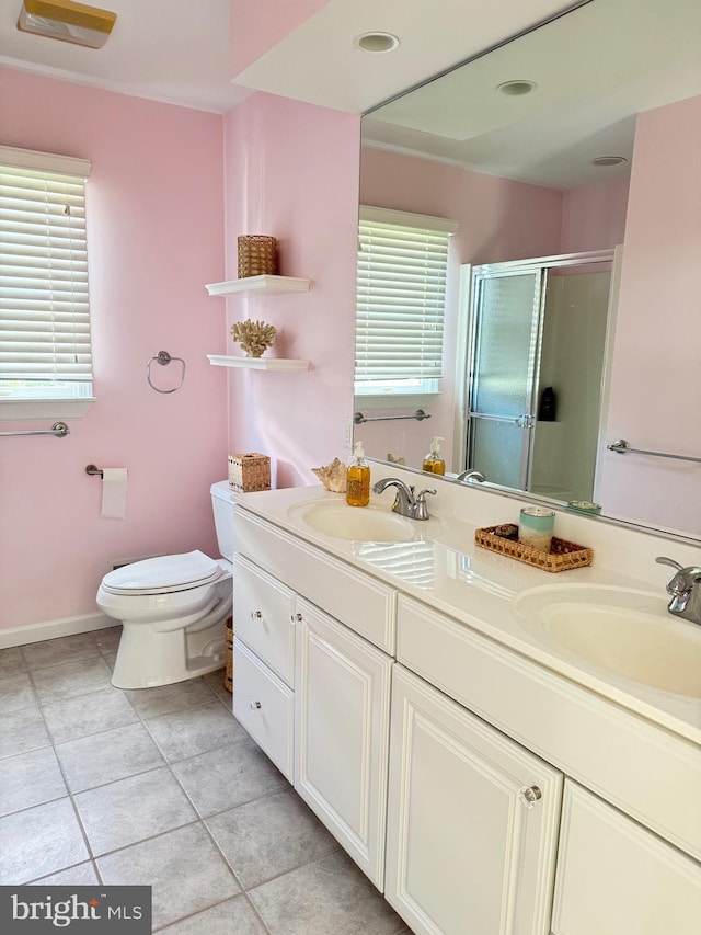 bathroom with vanity, toilet, a shower with door, and tile patterned floors