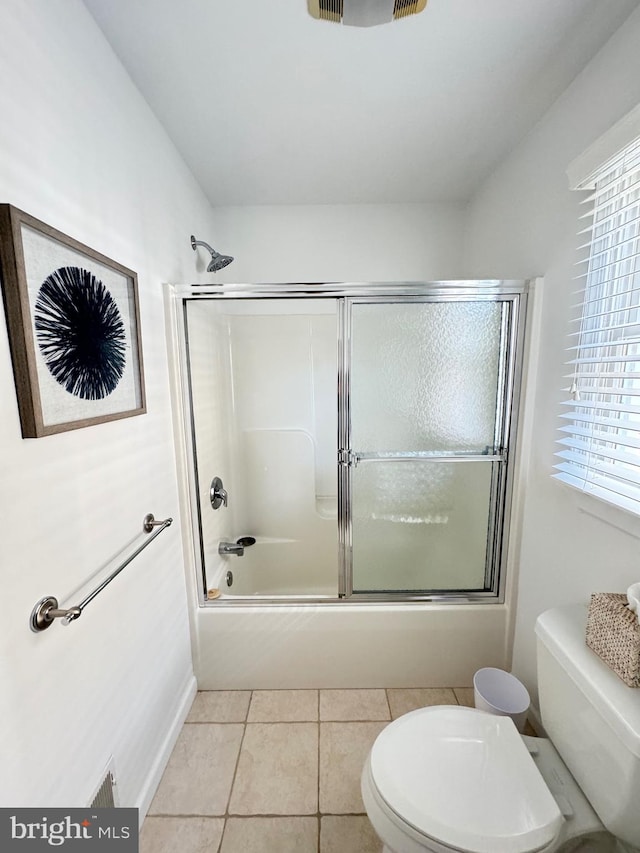 bathroom with plenty of natural light, shower / bath combination with glass door, and toilet