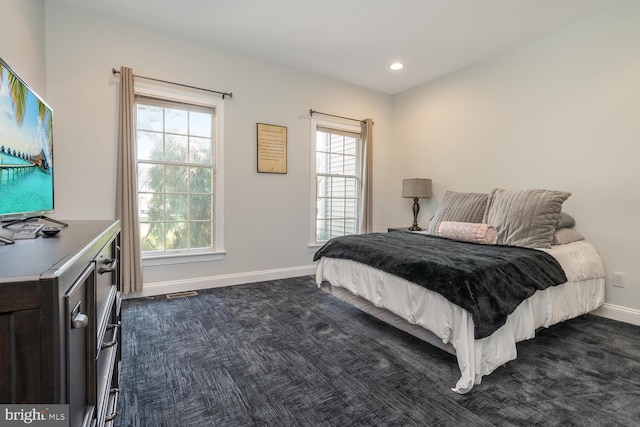 carpeted bedroom featuring multiple windows