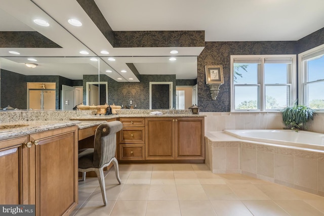 bathroom with tile patterned floors, vanity, and a relaxing tiled tub