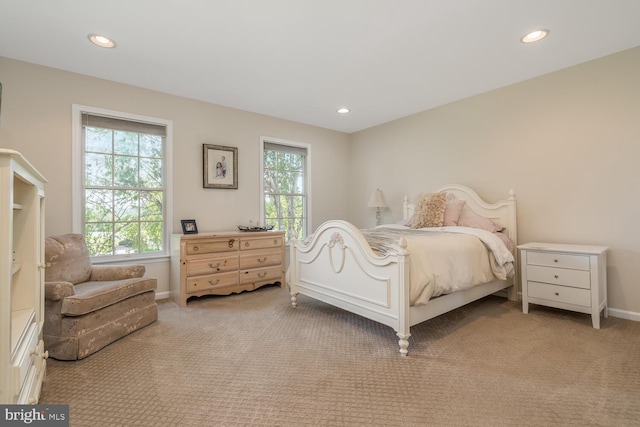 bedroom with light colored carpet and multiple windows