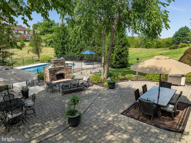 view of patio / terrace featuring a fenced in pool and an outdoor stone fireplace