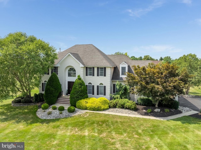 colonial home featuring a front lawn