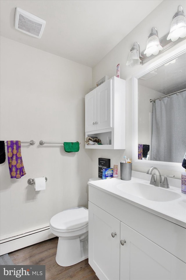 bathroom featuring vanity, wood-type flooring, a shower with curtain, a baseboard radiator, and toilet