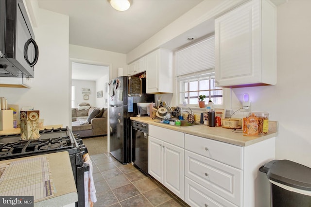 kitchen featuring sink, white cabinetry, and black appliances