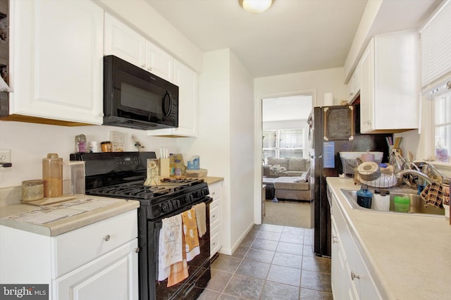 kitchen featuring black appliances, sink, and white cabinets