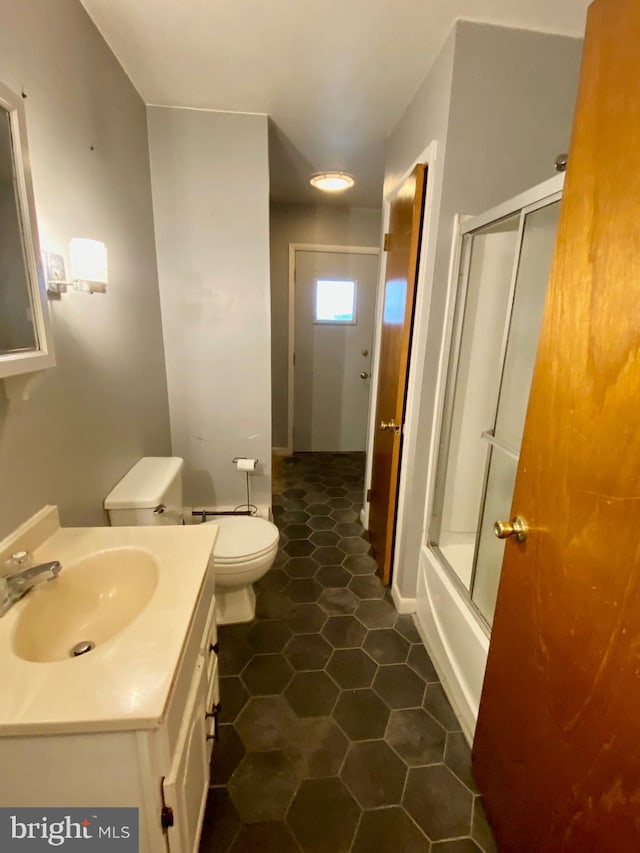 full bathroom featuring bath / shower combo with glass door, tile patterned flooring, vanity, and toilet