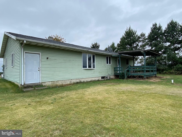 rear view of house featuring a lawn and a deck