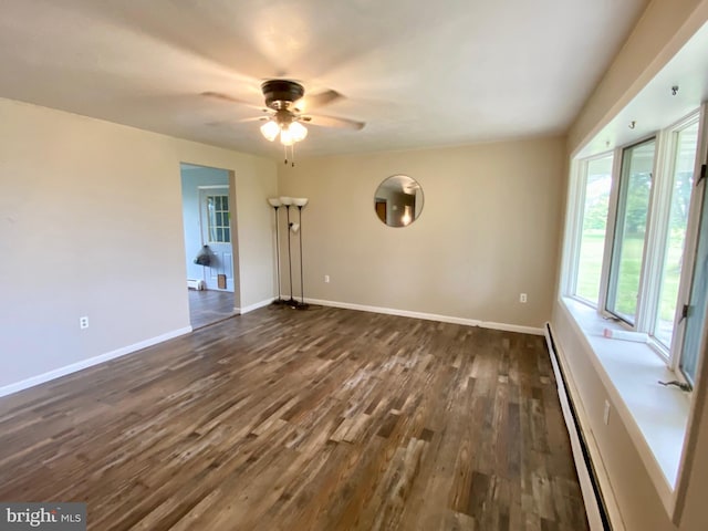 unfurnished room featuring ceiling fan, dark wood-type flooring, and baseboard heating