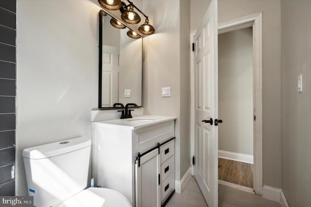 bathroom with wood-type flooring, vanity, and toilet