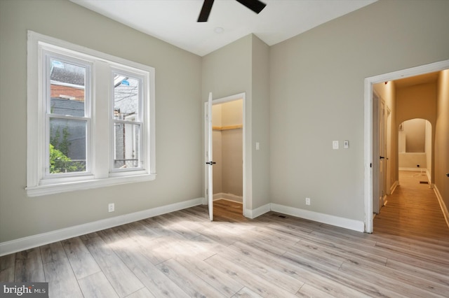 unfurnished bedroom with ceiling fan, a closet, and light hardwood / wood-style flooring