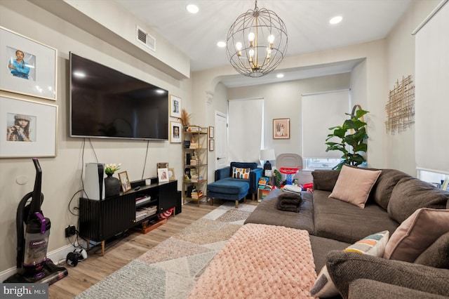 living room with a notable chandelier and light hardwood / wood-style floors