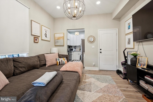 living room with an inviting chandelier and light wood-type flooring