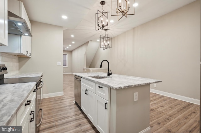 kitchen featuring stainless steel appliances, white cabinets, a center island with sink, and sink